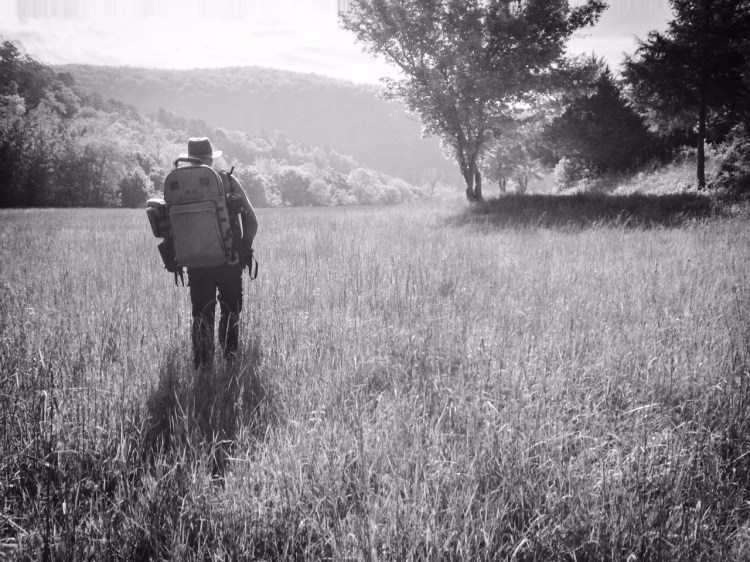 Tim Ernst leads our group of students across a meadow at Steel Creek Campground